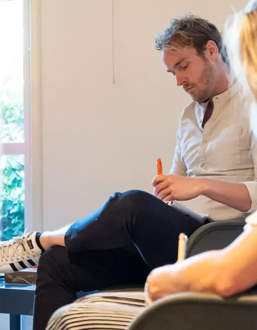 Coach in gesprek met cliënt tijdens een sessie in Amsterdam – lichaamsgerichte coaching voor homoseksuele mannen
